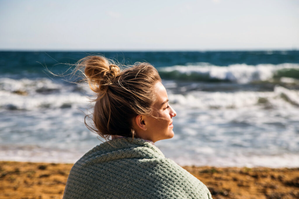 woman sitting at the shore line on a sunny day