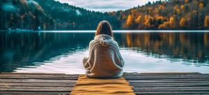 young woman sitting on a dock by the lake